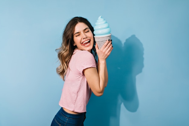 Foto gratuita mujer morena soñadora comiendo helado