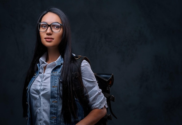 Mujer morena viajera positiva con anteojos vestida con una camisa de mezclilla.