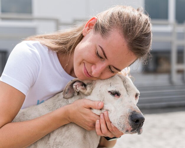 Mujer mostrando afecto al lindo perro de rescate en el refugio