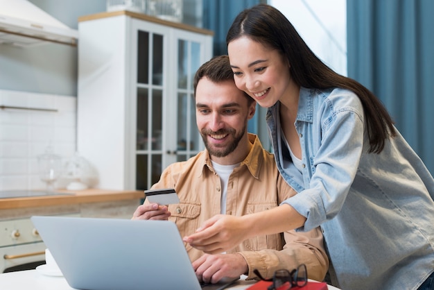 Mujer mostrando al hombre en la computadora portátil lo que quiere comprar en línea