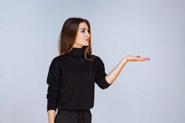 mujer mostrando algo en el lado derecho.