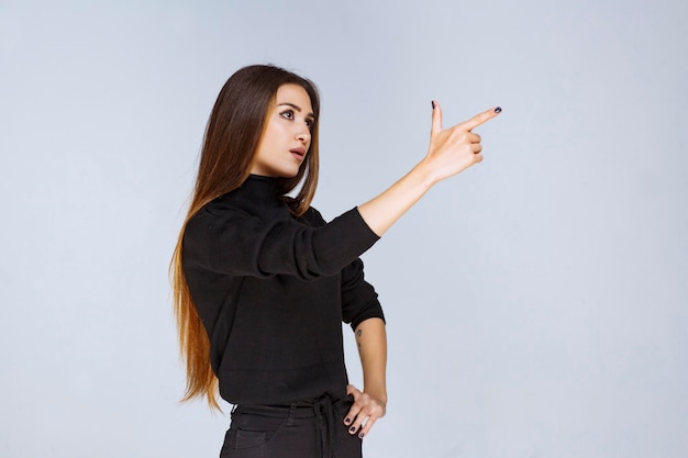 mujer mostrando algo en el lado derecho.