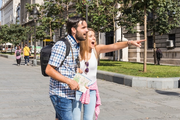 Mujer mostrando algo a su novio mientras disfruta de vacaciones