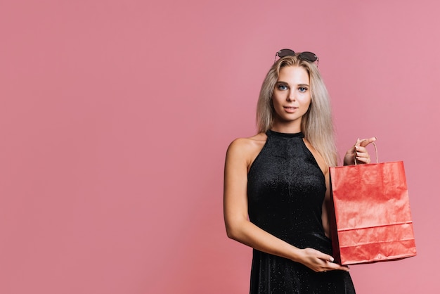 Foto gratuita mujer mostrando bolsa de papel roja