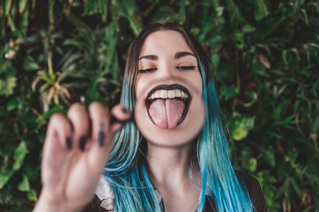 Mujer mostrando la lengua a través de una lupa.