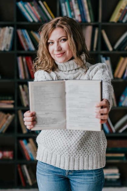 Foto gratuita mujer mostrando un libro abierto