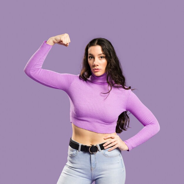 Mujer mostrando músculos y con un top violeta