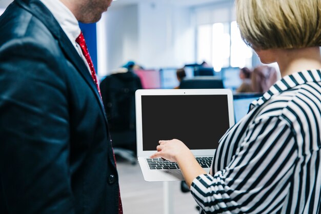 Foto gratuita mujer mostrando portátil a compañero de trabajo