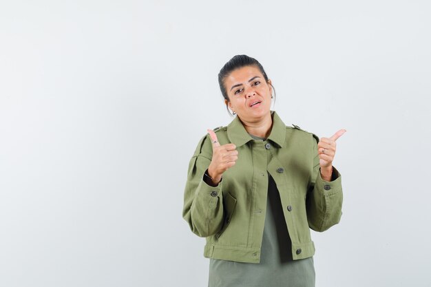 mujer mostrando los pulgares para arriba en chaqueta, camiseta y mirando satisfecho