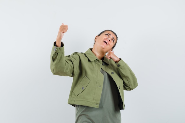 mujer mostrando los pulgares para arriba en chaqueta, camiseta y con suerte.