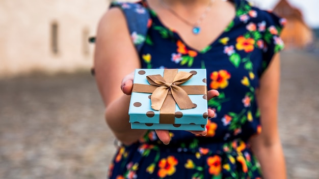 Mujer mostrando regalo en la calle.