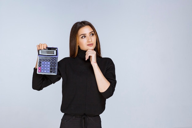 mujer mostrando el resultado final en la calculadora.