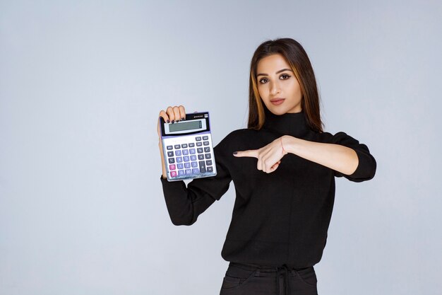 mujer mostrando el resultado final en la calculadora.