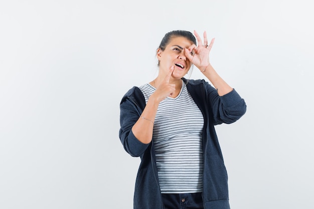 Mujer mostrando signo ok en el ojo en camiseta