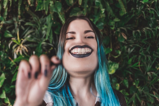 Mujer mostrando una sonrisa dentuda a través de una lupa.