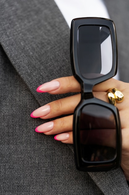 Foto gratuita mujer mostrando su arte de uñas en las uñas con gafas de sol