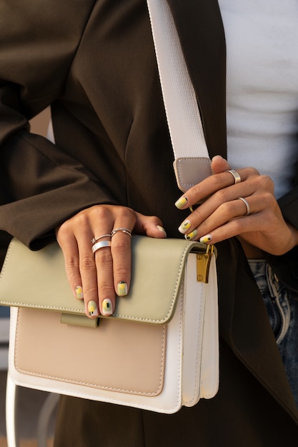 Foto gratuita mujer mostrando su arte de uñas en las uñas con monedero