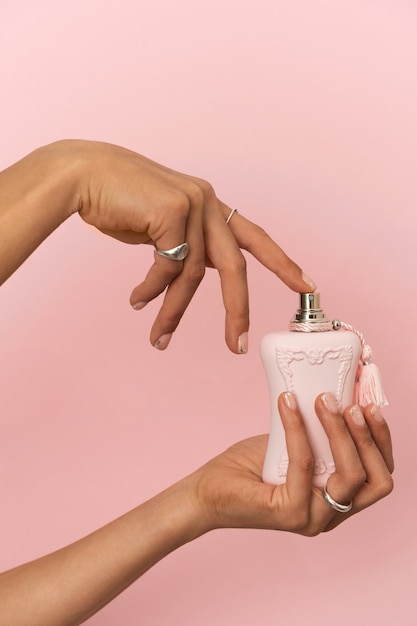 Foto gratuita mujer mostrando su arte de uñas en las uñas con perfume