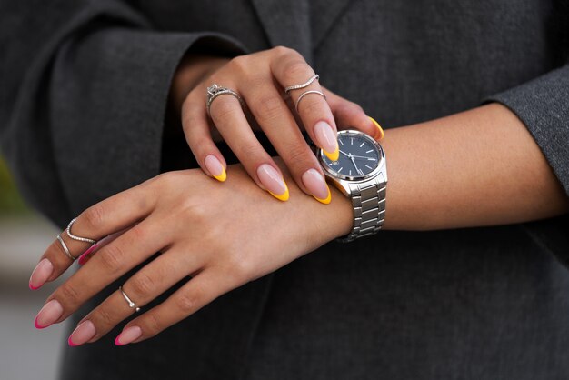 Mujer mostrando su arte de uñas en las uñas con reloj