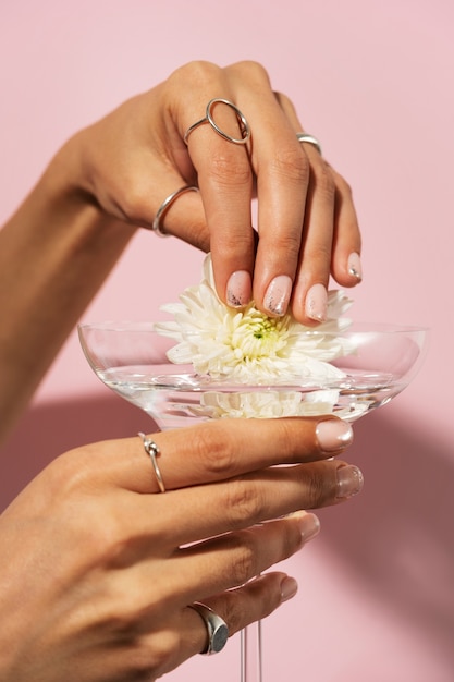 Mujer mostrando su arte de uñas en las uñas con vidrio