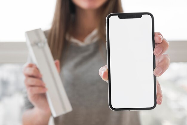 Mujer mostrando teléfono inteligente en la mano