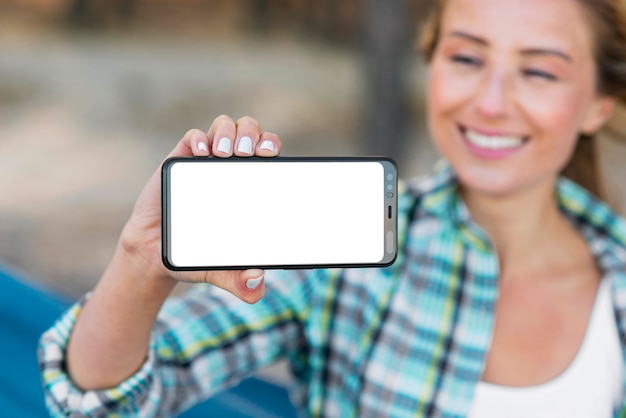 Mujer mostrando teléfono móvil de espacio de copia horizontal