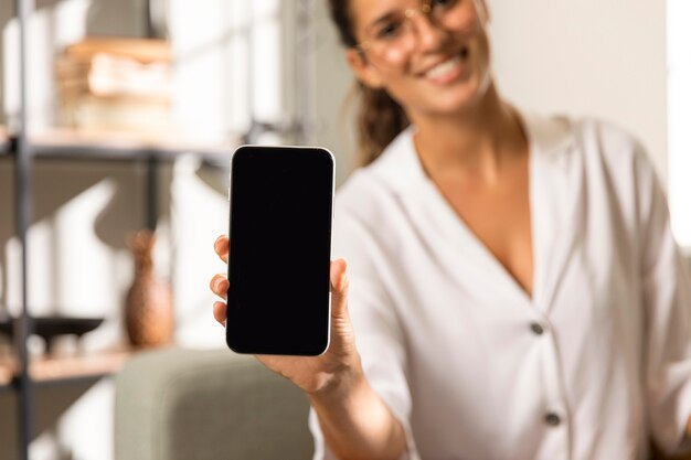 Mujer mostrando teléfono de tablón