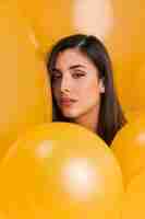 Foto gratuita mujer entre muchos globos amarillos