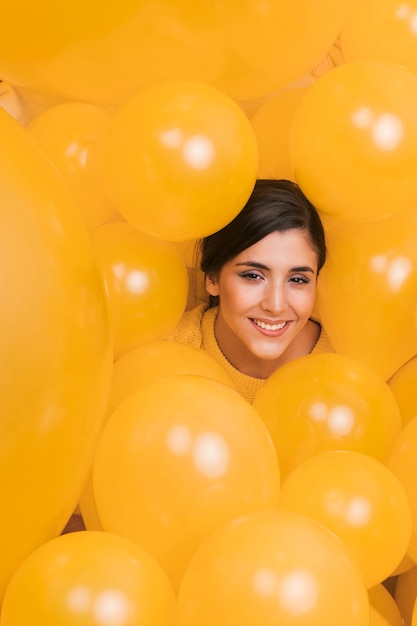 Mujer entre muchos globos amarillos