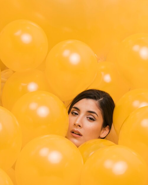 Mujer entre muchos globos amarillos