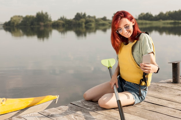 Foto gratuita mujer en muelle sosteniendo paleta