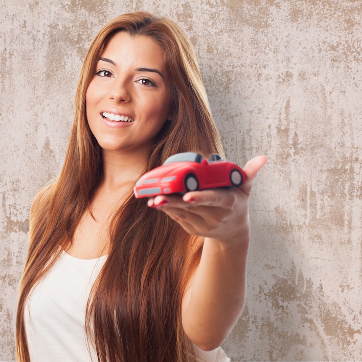 Foto gratuito la mujer muestra el coche de juguete.