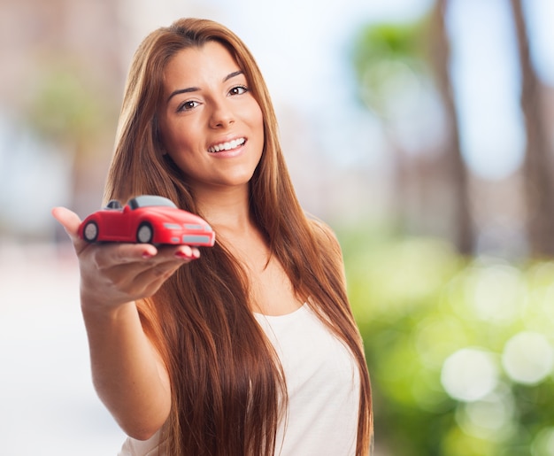 Foto gratuita la mujer muestra el coche de juguete.