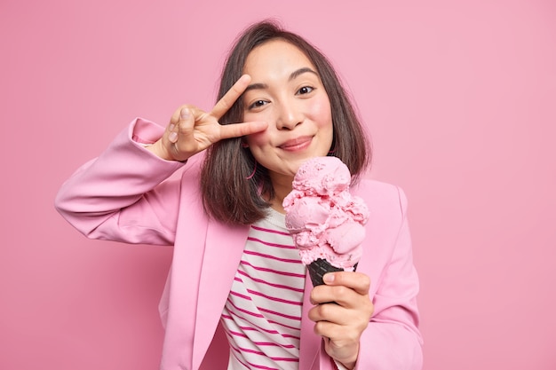 Foto gratuita mujer muestra gesto de paz sostiene gelato