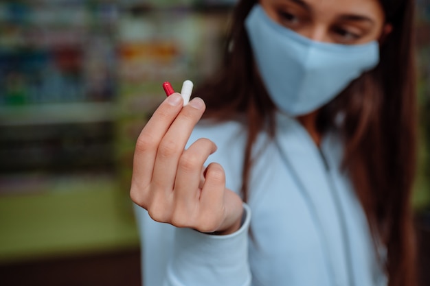 La mujer muestra pastillas, vitaminas o pastillas en la mano. covid-19.