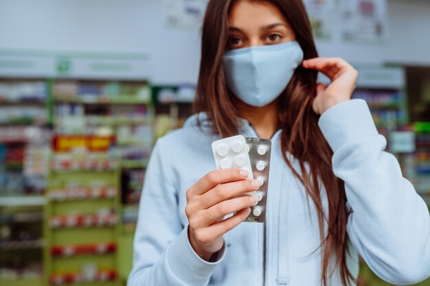 La mujer muestra píldoras, vitaminas o píldoras en su mano. COVID-19.