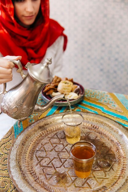 Mujer musulmana echando té