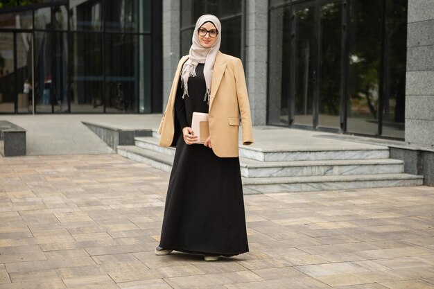 Mujer musulmana con estilo moderno en hijab en la calle de la ciudad