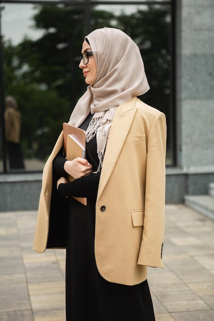 Mujer musulmana con estilo moderno en hijab en la calle de la ciudad