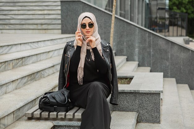 Mujer musulmana con estilo moderno en hijab en la calle de la ciudad