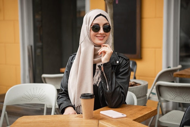 Mujer musulmana con estilo moderno en hijab en la calle de la ciudad