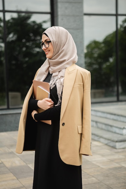 Foto gratuita mujer musulmana en hiyab en la calle de la ciudad