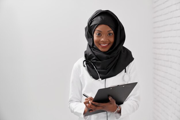 Mujer musulmana con hiyab negro trabajando en el hospital