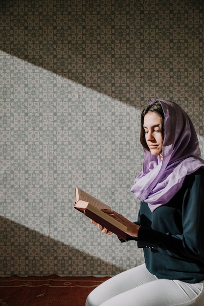 Foto gratuita mujer musulmana leyendo en corán