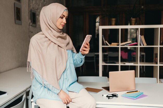 Mujer musulmana moderna en hijab en la sala de oficina