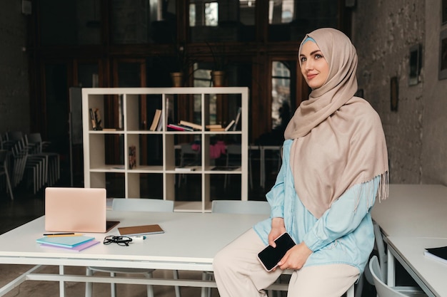 Mujer musulmana moderna en hijab en la sala de oficina