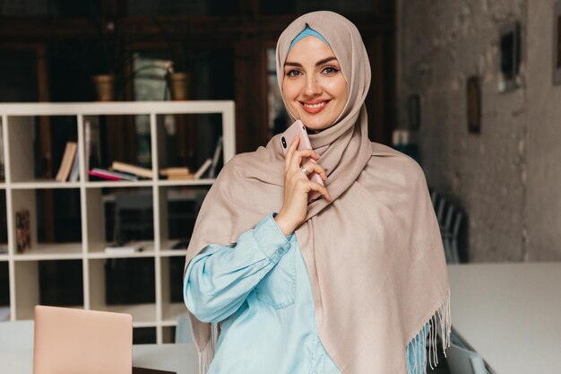 Mujer musulmana moderna en hijab en la sala de oficina