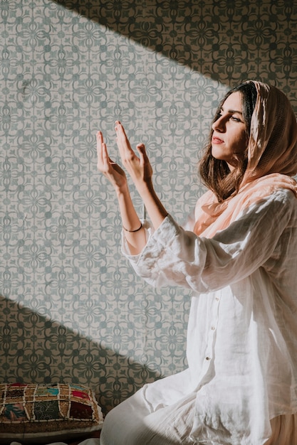 Mujer musulmana rezando con luz solar