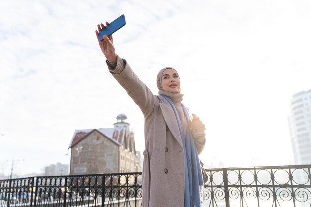 Mujer musulmana tomando un selfie mientras viaja