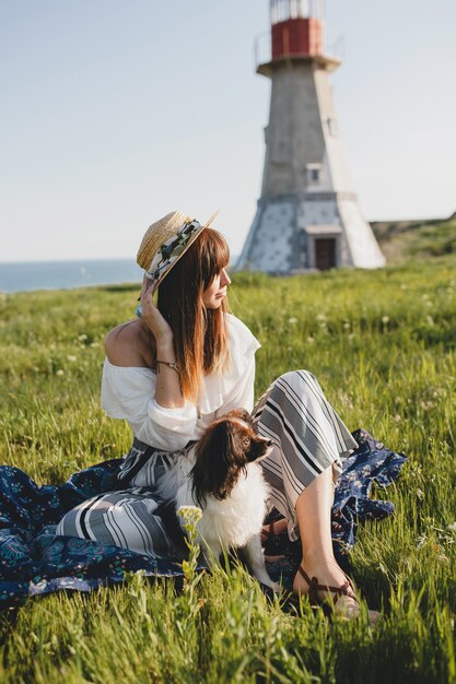 Mujer muy elegante en el campo, con un perro